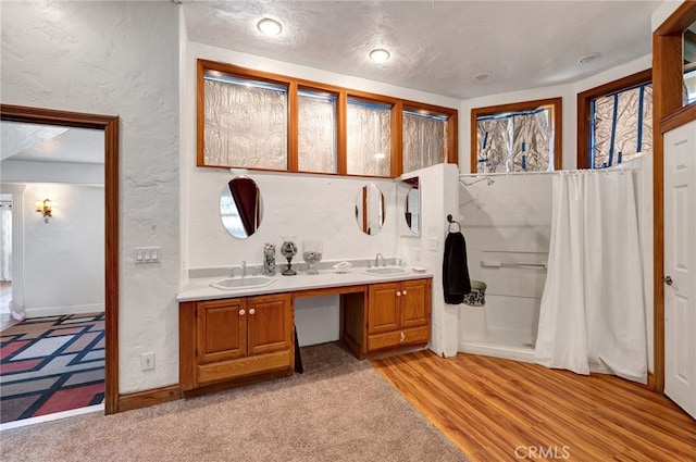 bathroom featuring vanity, hardwood / wood-style flooring, a textured ceiling, and curtained shower