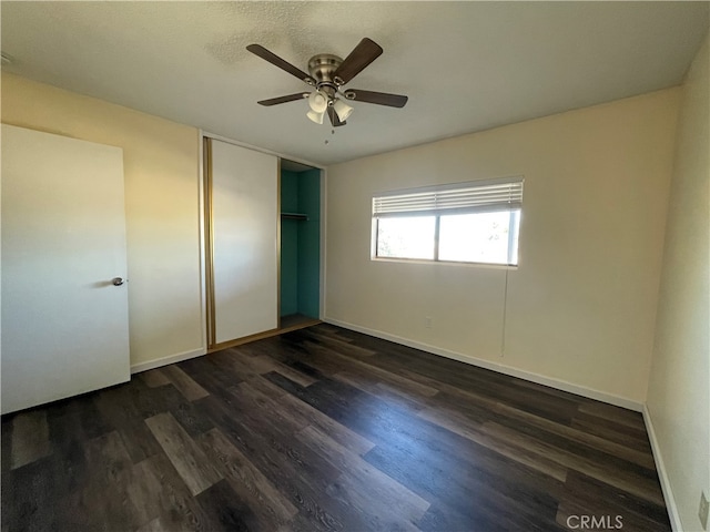 unfurnished bedroom with dark hardwood / wood-style floors, a closet, and ceiling fan