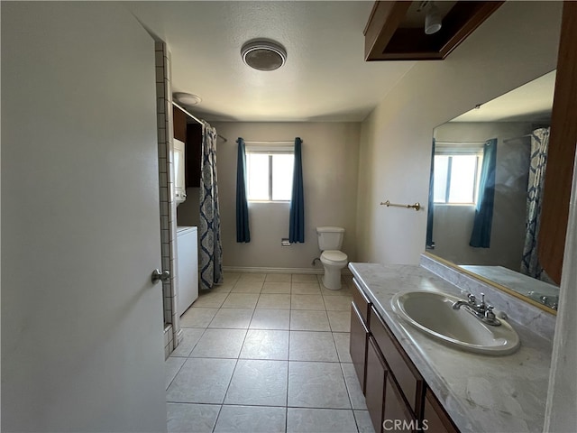 bathroom with washer / dryer, vanity, toilet, and tile patterned flooring