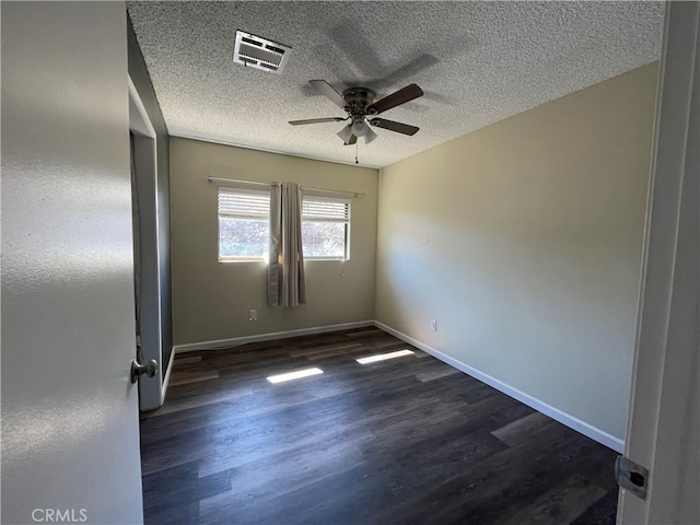 empty room featuring ceiling fan, a textured ceiling, and dark hardwood / wood-style flooring