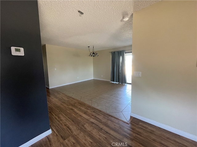 spare room featuring hardwood / wood-style flooring and a textured ceiling