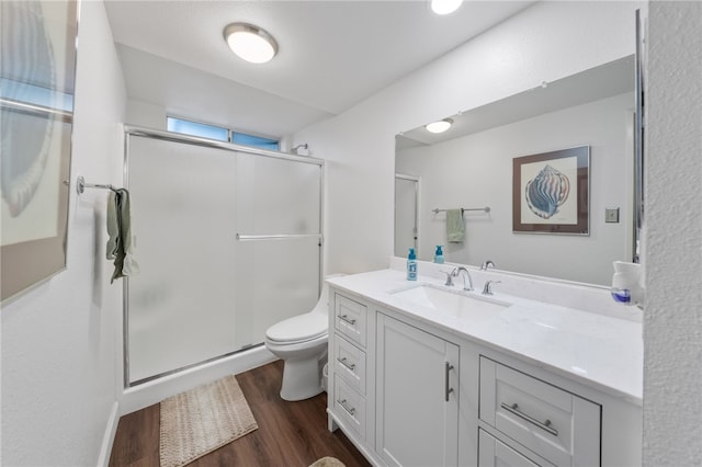 bathroom featuring walk in shower, vanity, toilet, and hardwood / wood-style flooring