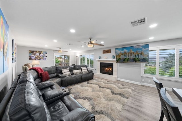 living room with light hardwood / wood-style flooring, ceiling fan, and a healthy amount of sunlight