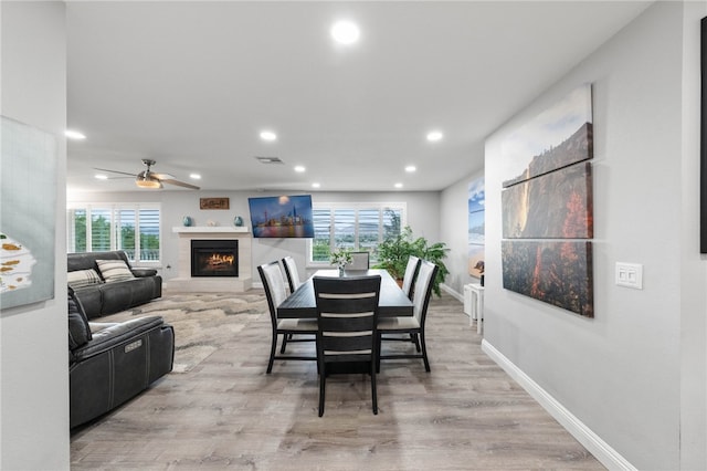 dining space with light hardwood / wood-style flooring and ceiling fan