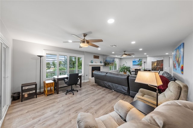 living room with light wood-type flooring and ceiling fan