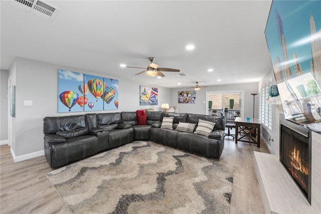 living room with light wood-type flooring and ceiling fan