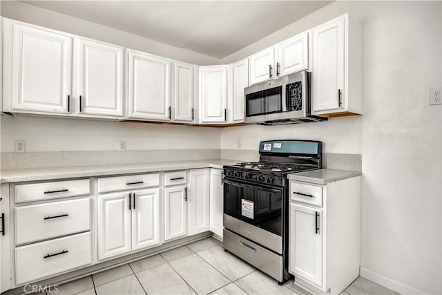 kitchen featuring light tile patterned flooring, white cabinetry, and stainless steel appliances