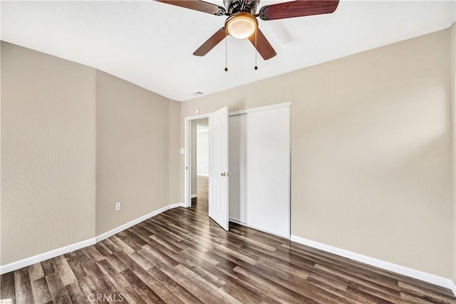 unfurnished bedroom featuring ceiling fan, a closet, and dark hardwood / wood-style floors