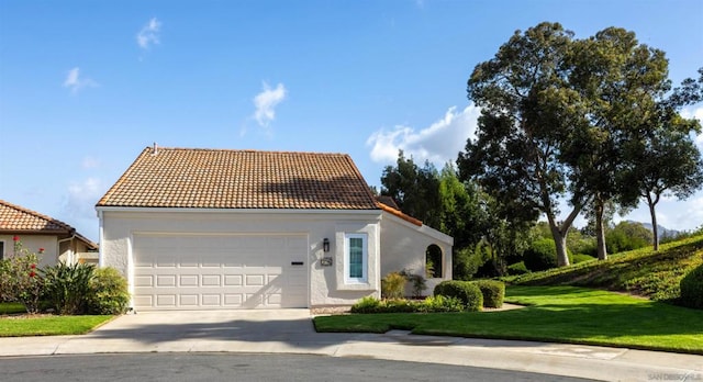 mediterranean / spanish house featuring a front lawn and a garage