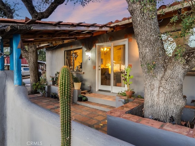 back house at dusk featuring a patio area