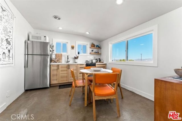 dining area featuring lofted ceiling and sink