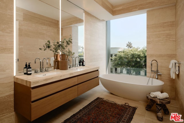 bathroom featuring tile walls, a wealth of natural light, a bath, and vanity