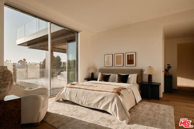 bedroom featuring wood-type flooring and access to outside