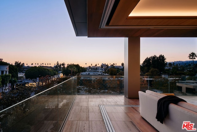 patio terrace at dusk featuring a balcony