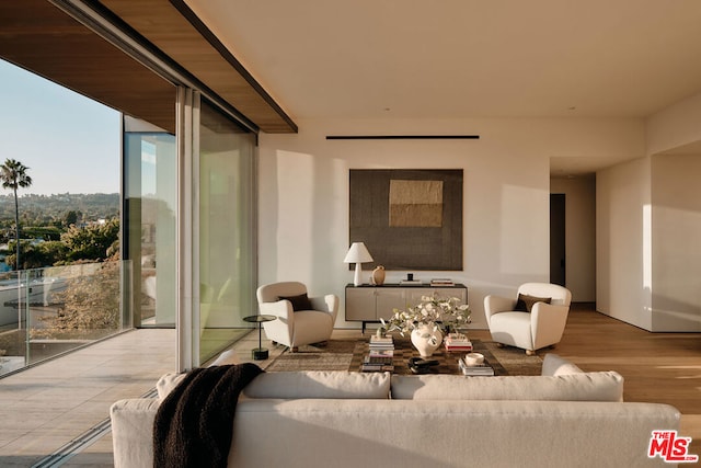 living room featuring light wood-type flooring and floor to ceiling windows