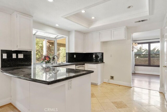 kitchen with decorative backsplash, white cabinetry, and plenty of natural light