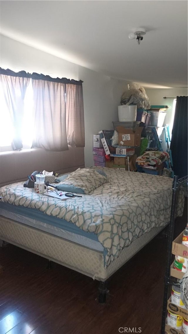 bedroom with dark hardwood / wood-style floors and multiple windows