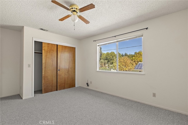 unfurnished bedroom featuring a closet, carpet floors, a textured ceiling, and ceiling fan