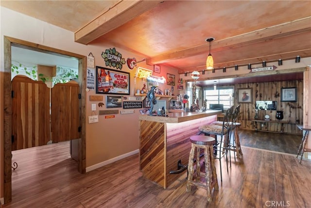 bar featuring wood-type flooring, hanging light fixtures, and beamed ceiling