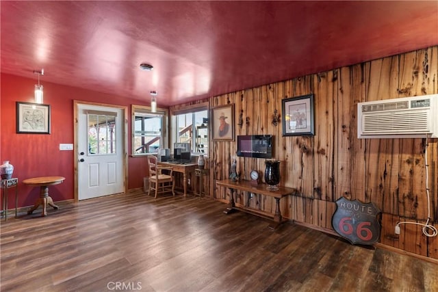 interior space with a wall mounted AC, dark wood-type flooring, and wooden walls