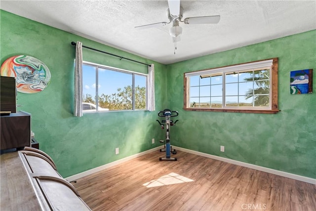 interior space with hardwood / wood-style flooring, ceiling fan, and a textured ceiling