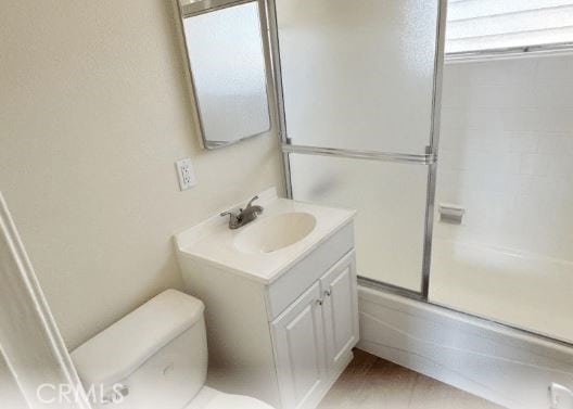 full bathroom with combined bath / shower with glass door, vanity, and toilet