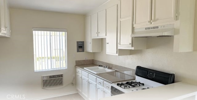 kitchen featuring white cabinets, stove, sink, and custom exhaust hood