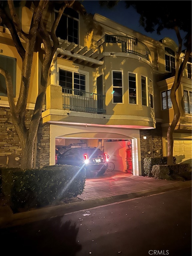 view of front of home with a balcony and a garage