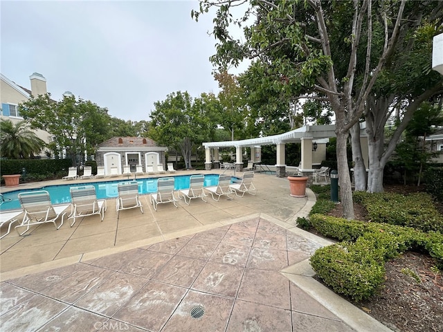 view of swimming pool featuring a patio and an outbuilding