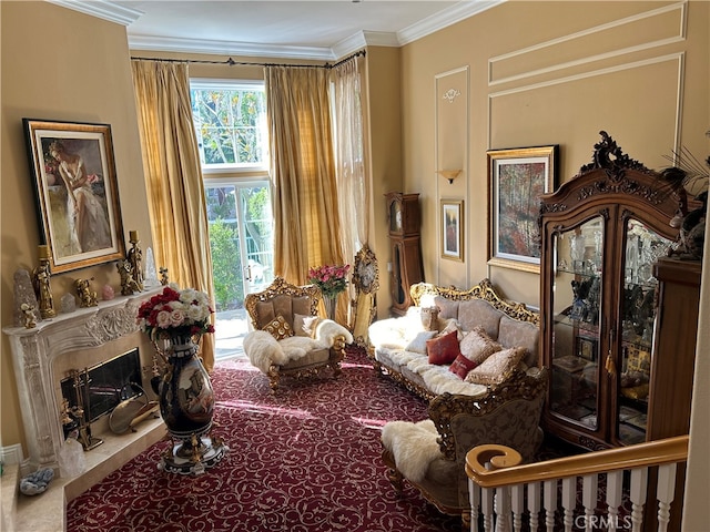 living area with a fireplace and ornamental molding