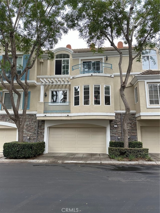 multi unit property with a balcony and a garage