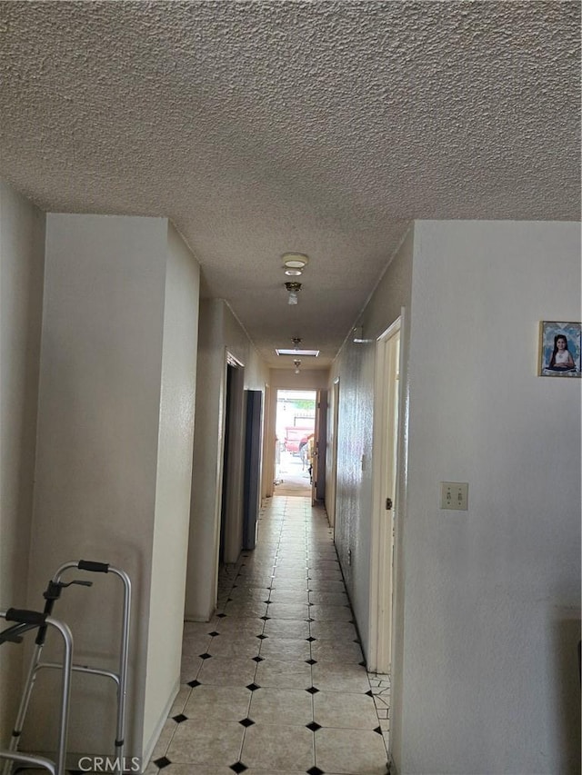 hallway with a textured ceiling