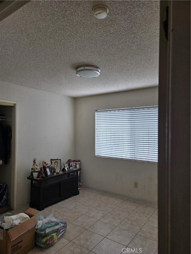 tiled bedroom with a textured ceiling