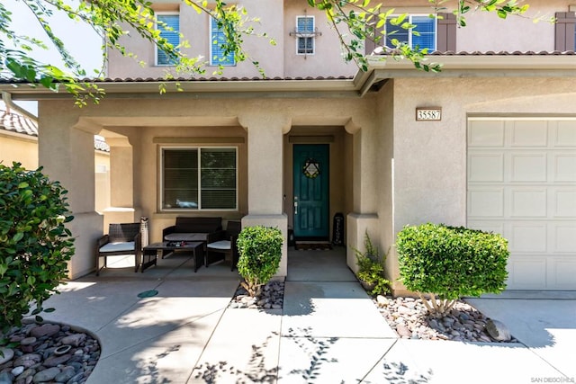 view of exterior entry featuring a porch and a garage