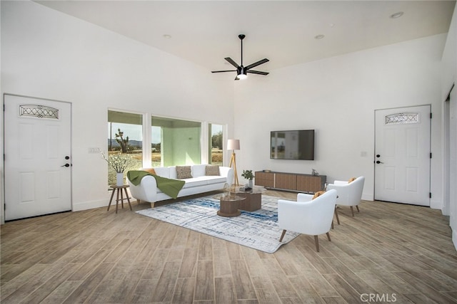 living room with high vaulted ceiling, ceiling fan, and hardwood / wood-style floors