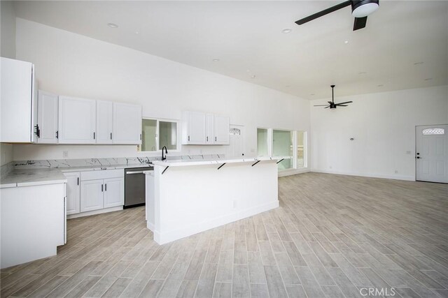 kitchen with light hardwood / wood-style flooring, white cabinets, and ceiling fan