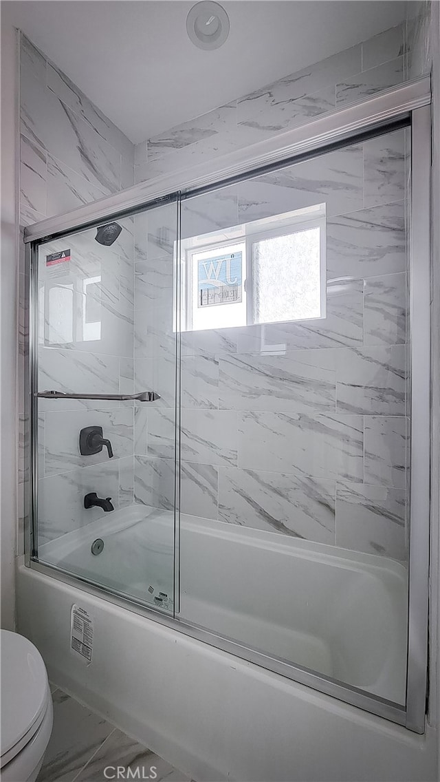 bathroom with shower / bath combination with glass door and toilet