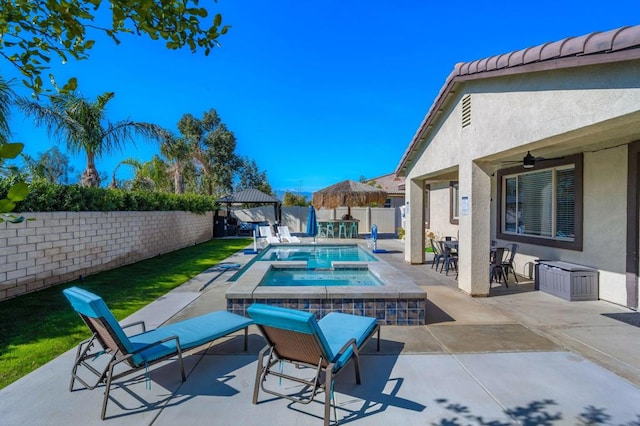 view of pool featuring ceiling fan, a patio, and an in ground hot tub