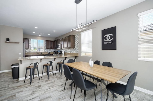 dining space with light wood-type flooring and sink