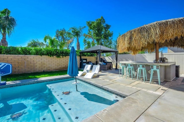 view of pool featuring exterior bar, a patio area, and a gazebo