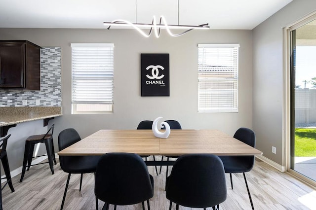 dining space with an inviting chandelier and light hardwood / wood-style floors