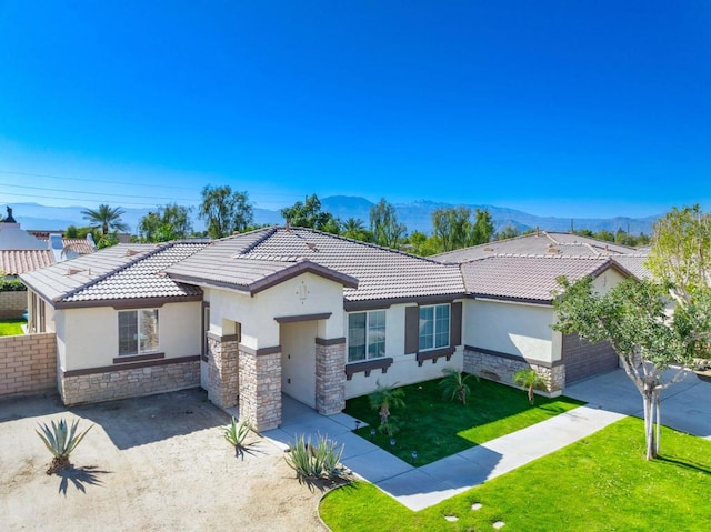 view of front of house featuring a garage, a mountain view, and a front lawn