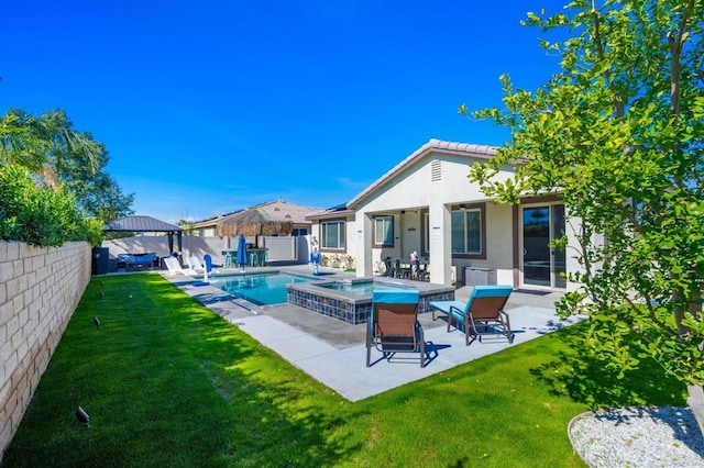 rear view of house with a fenced in pool, a yard, and a patio