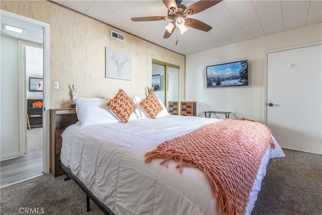 carpeted bedroom featuring a closet, ceiling fan, and visible vents