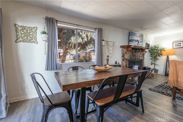 dining room with a fireplace and hardwood / wood-style floors