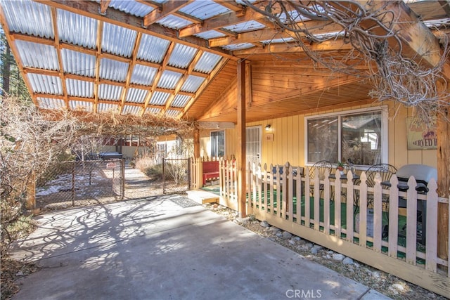 exterior space with concrete flooring and vaulted ceiling