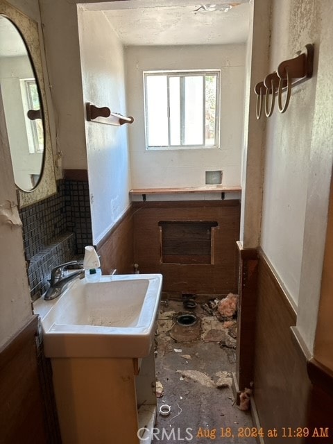 bathroom with wooden walls and sink