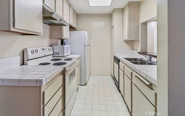 kitchen with tile countertops, sink, and white appliances