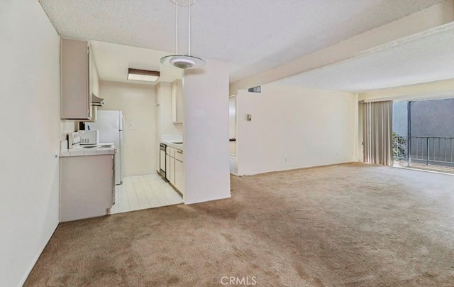 unfurnished living room with light colored carpet and a textured ceiling