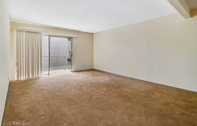 carpeted spare room with a textured ceiling and beam ceiling